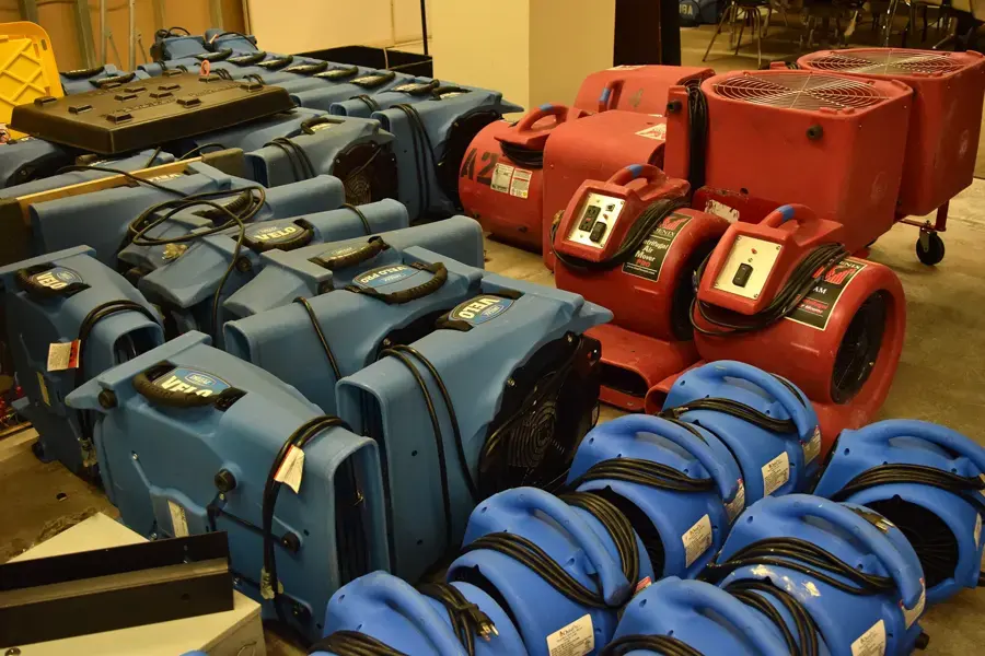 Rows of air movers and drying equipment staged for a structural dry-out